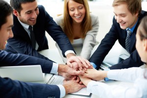 Image of business partners making pile of hands at meeting